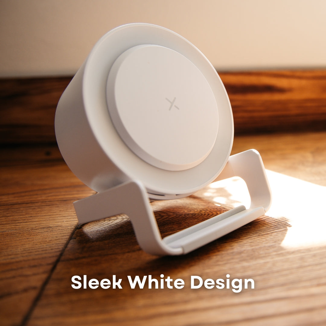 White speaker wireless charger on wooden surface in natural sunlight showing LED ring detail and phone stand