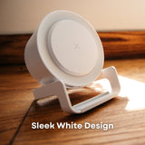 White speaker wireless charger on wooden surface in natural sunlight showing LED ring detail and phone stand