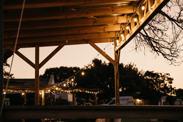 Wooden structure with string lights against a dusk sky