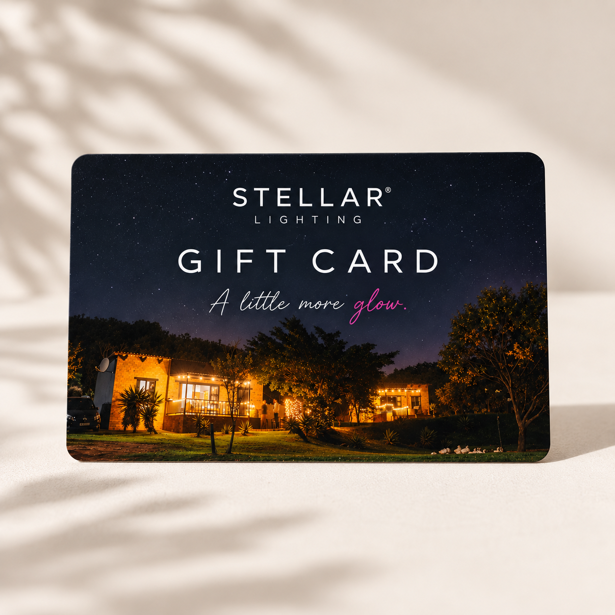 Stellar Lighting Gift Card featuring a starry night scene of a lit outdoor property