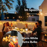 Group of friends laughing at an outdoor dinner table under Ultimate Festoon String Lights with 1m spacing callout and inset showing warm white G45 retro globe bulb detail