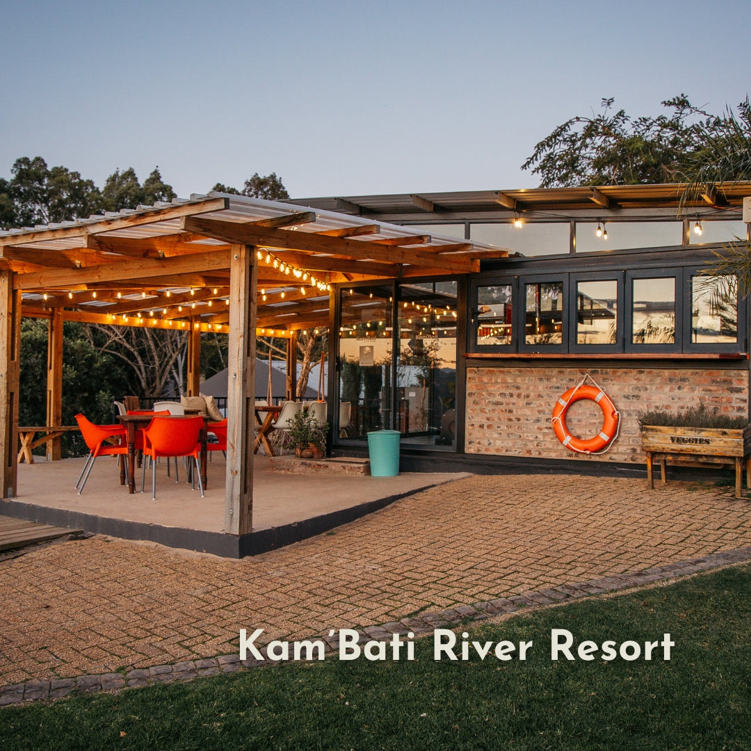 Vintage string lights strung across an outdoor restaurant terrace at Kam'Bati River Resort at dusk