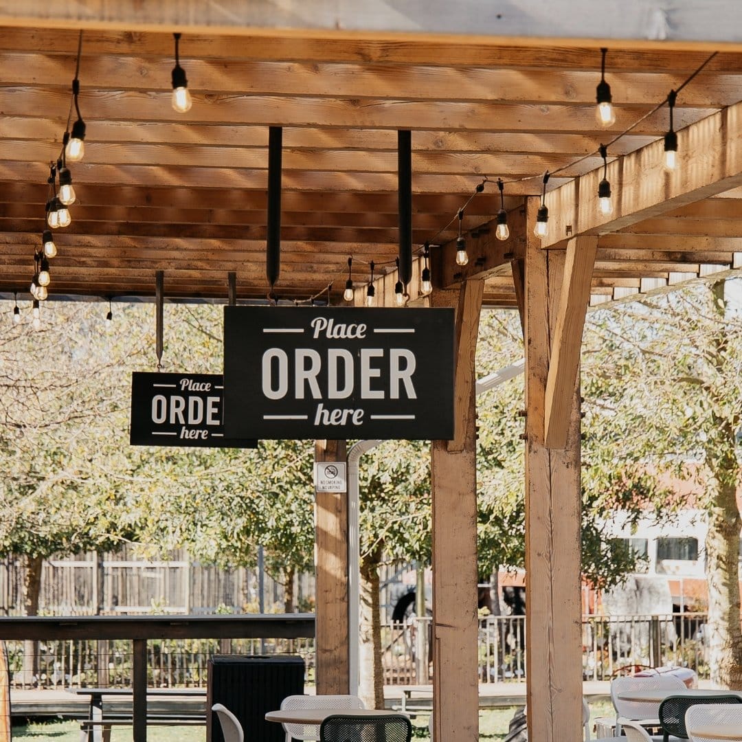 Vintage-style festoon bulbs glowing softly at dusk at Peregrine café area