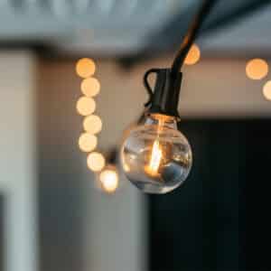 Outdoor black string lights with 25 warm LED bulbs creating a soft glow over a patio at night