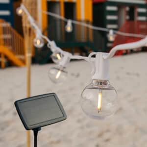 Solar string lights with 16 warm white LED bulbs and white cable.