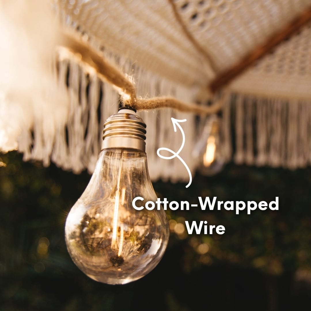 Solar powered cotton string lights with 10 warm LED bulbs hanging in a cosy covered patio setting.