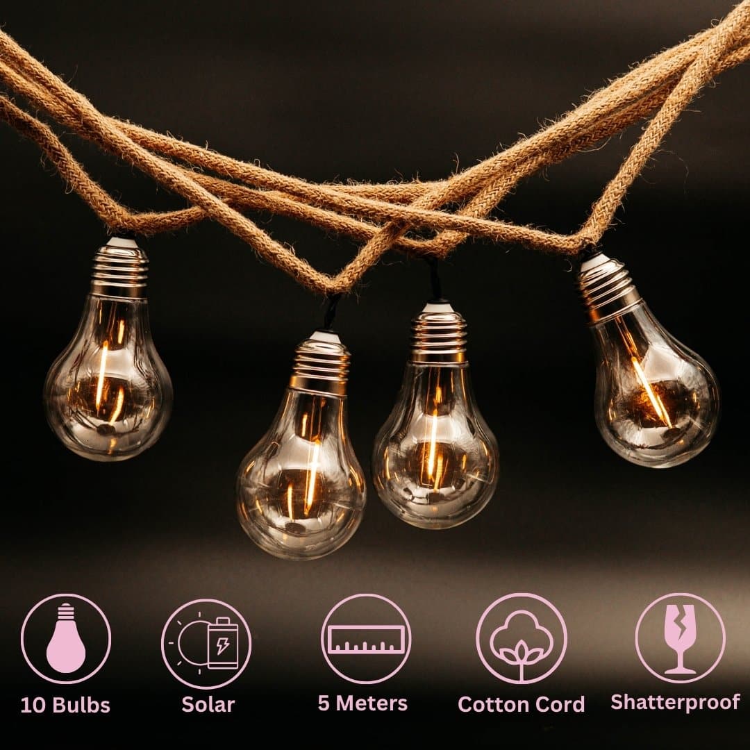 Solar powered cotton string lights with 10 warm LED bulbs hanging in a cosy covered patio setting.