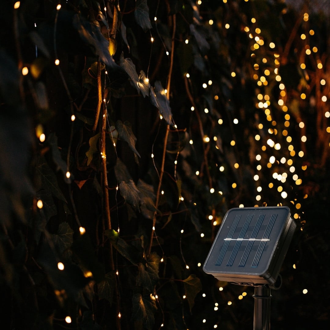 20m solar copper wire fairy lights glowing in a garden at night
