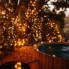 Subtle Solar Fairy Lights twinkling through the greenery beside an outdoor hot tub