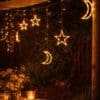 Moon and star curtain fairy lights with warm white glow in bedroom setting