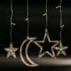 Moon and star curtain fairy lights with warm white glow in bedroom setting