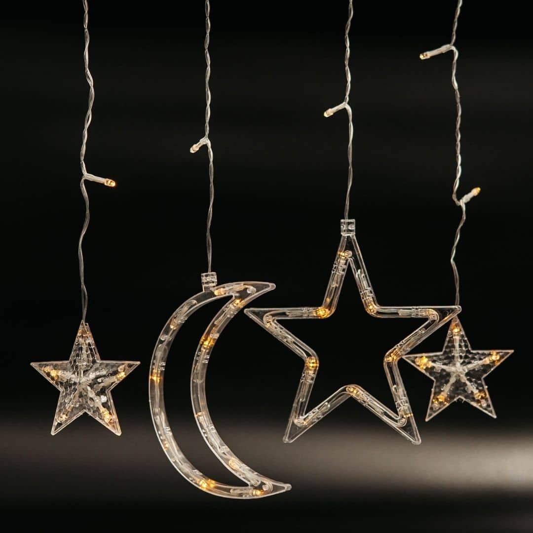 Moon and star curtain fairy lights with warm white glow in bedroom setting