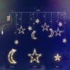 Moon and star curtain fairy lights with warm white glow in bedroom setting