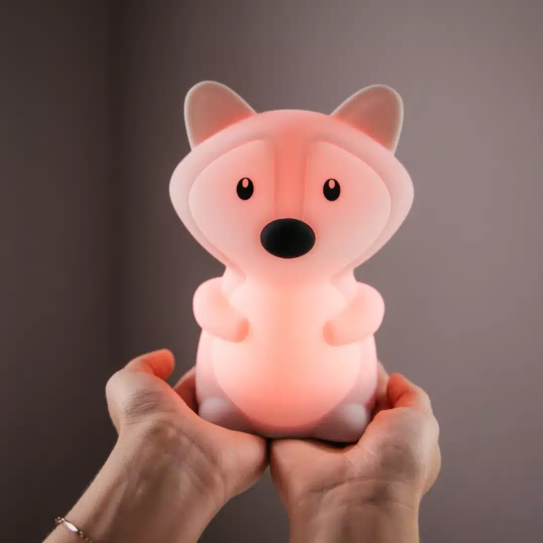 Person holding a fox-shaped night light emitting a gentle glow