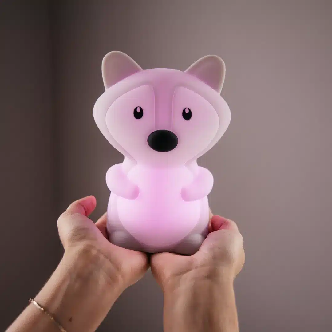 Person holding a fox-shaped night light emitting a gentle glow