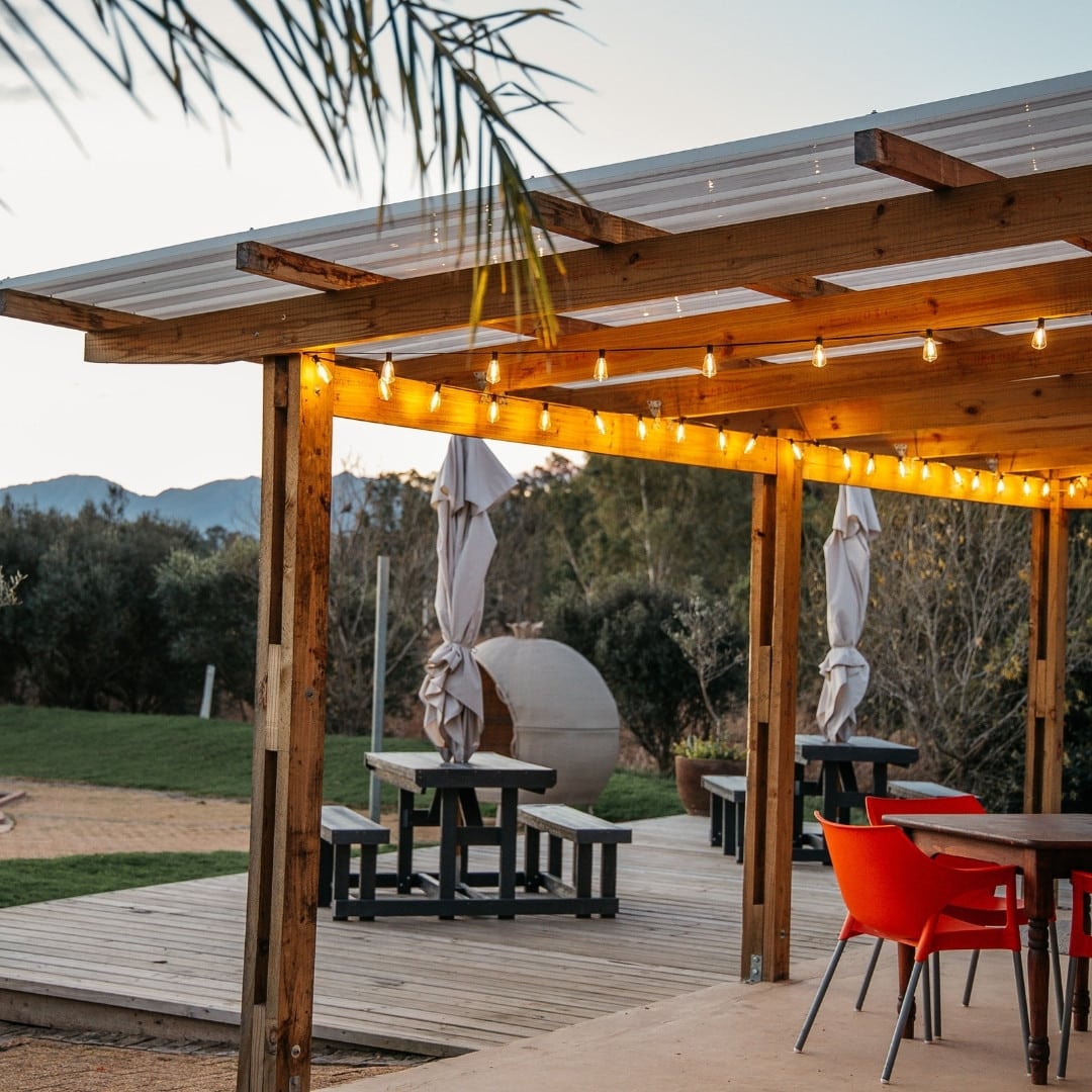 Outdoor table lit by hanging vintage LED string lights at Kam'Bati