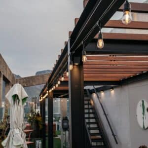 Warm white 10m plug-in festoon drop string lights by Stellar Lighting hanging over an outdoor dining area in South Africa.