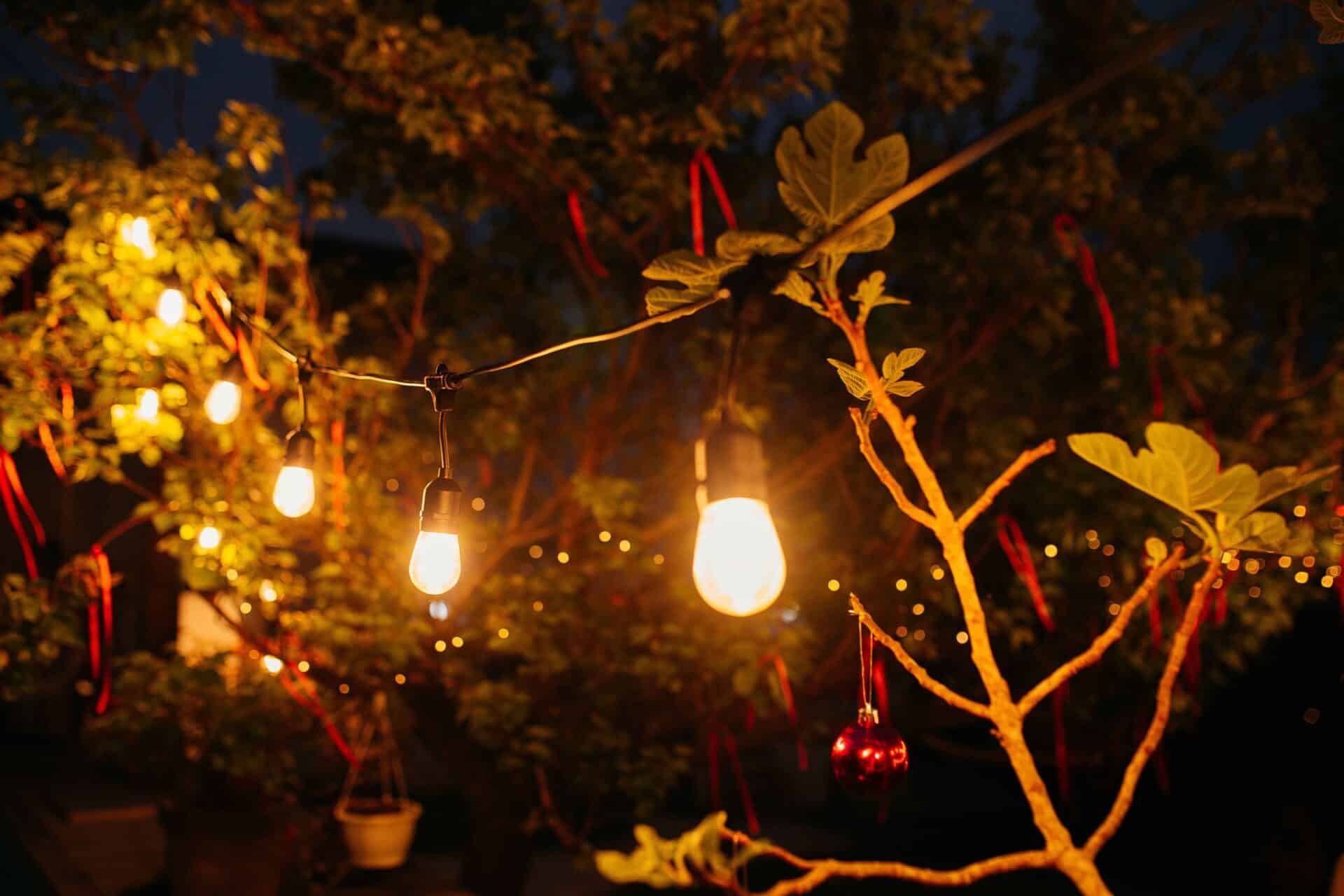 Warm white 10m plug-in festoon string lights by Stellar Lighting hanging over an outdoor dining area in South Africa.