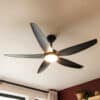 52-inch black ceiling fan with five sleek blades, remote control, and built-in light for efficient cooling and illumination.