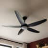 52-inch black ceiling fan with five sleek blades, remote control, and built-in light for efficient cooling and illumination.