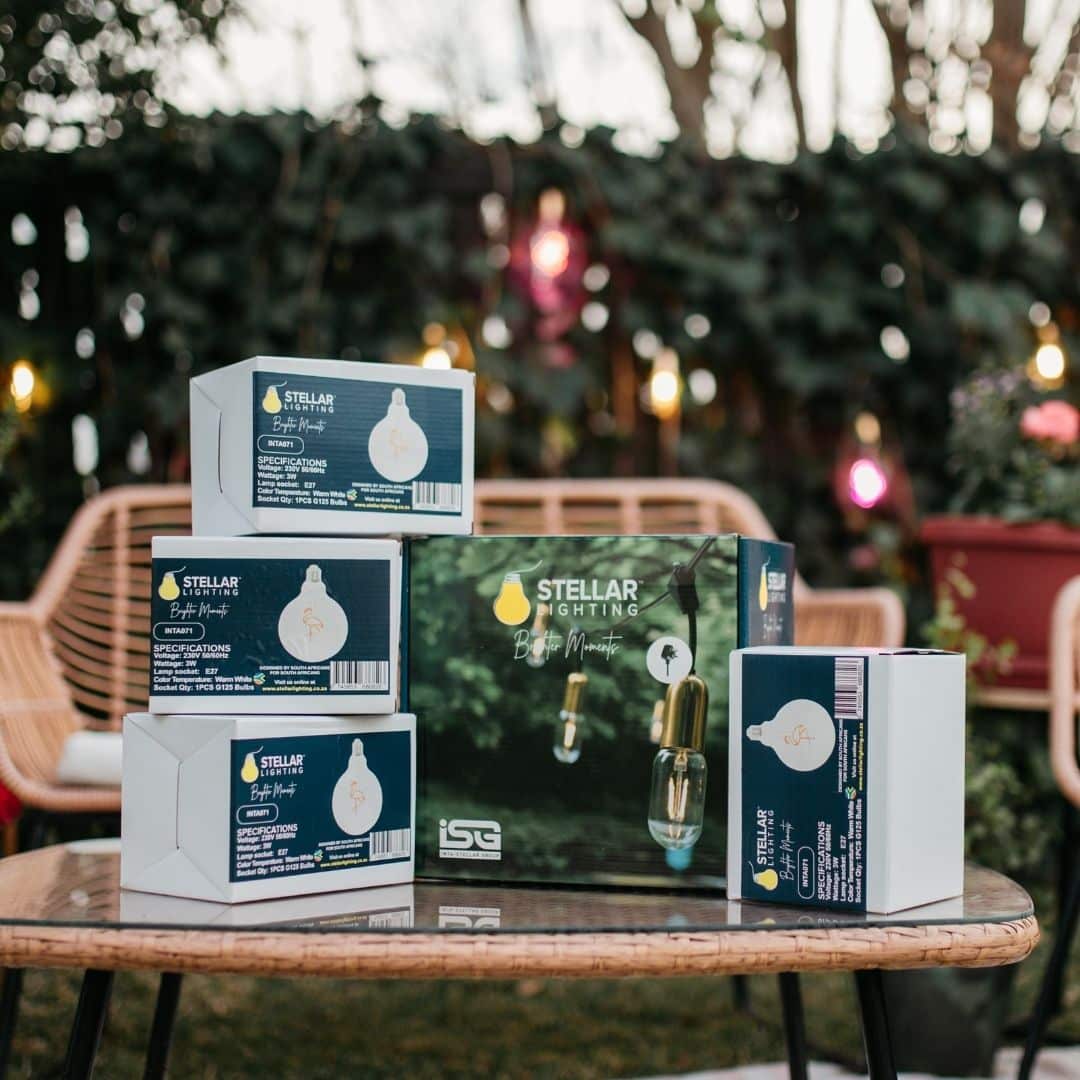 Four flamingo-pink LED bulbs with gold drop string lights styled for a warm indoor glow.