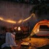 LED camping string light and rechargeable speaker lantern glowing in a cozy outdoor setting.