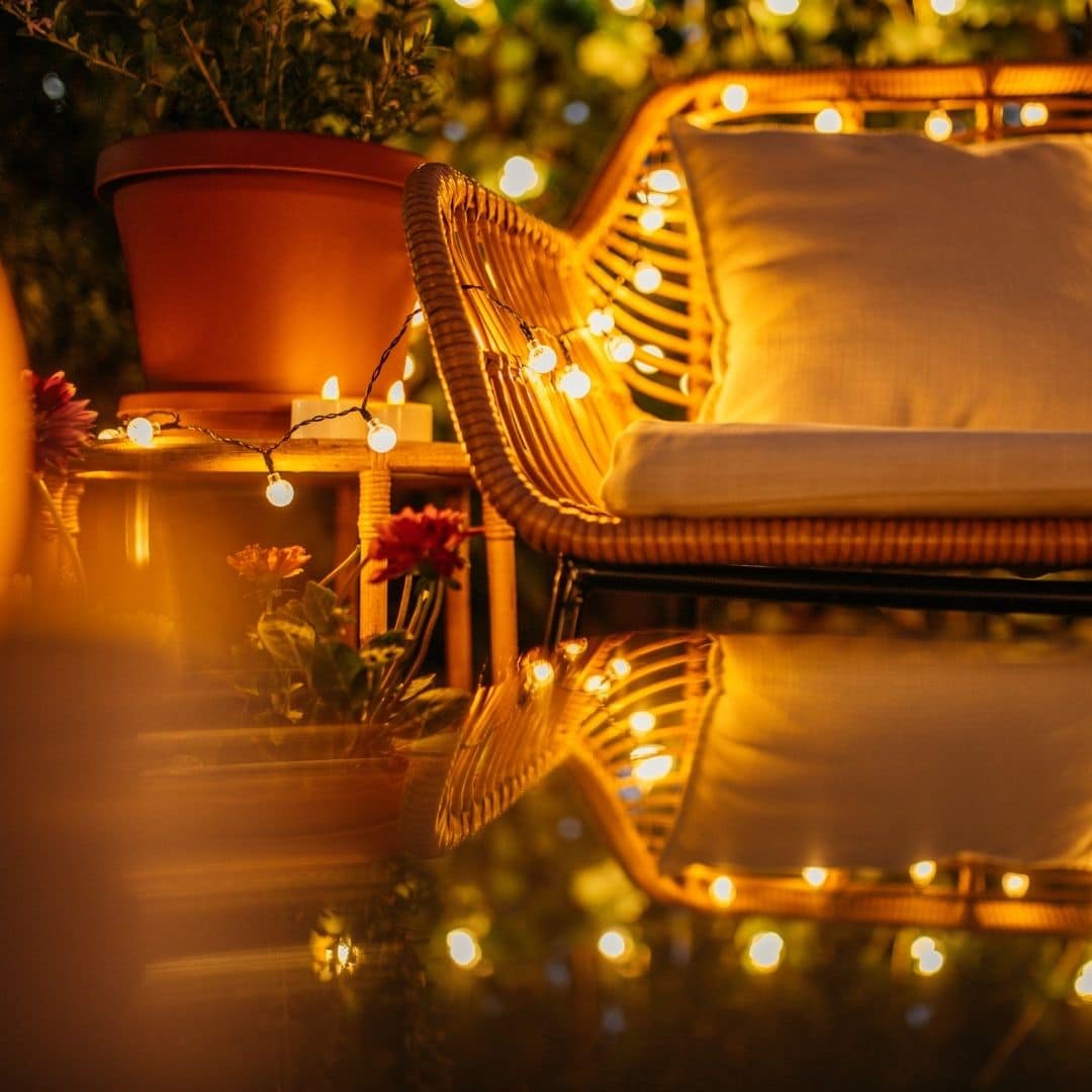 Romantic solar fairy lights, bubble lights, and flickering tea lights glowing under a tree.
