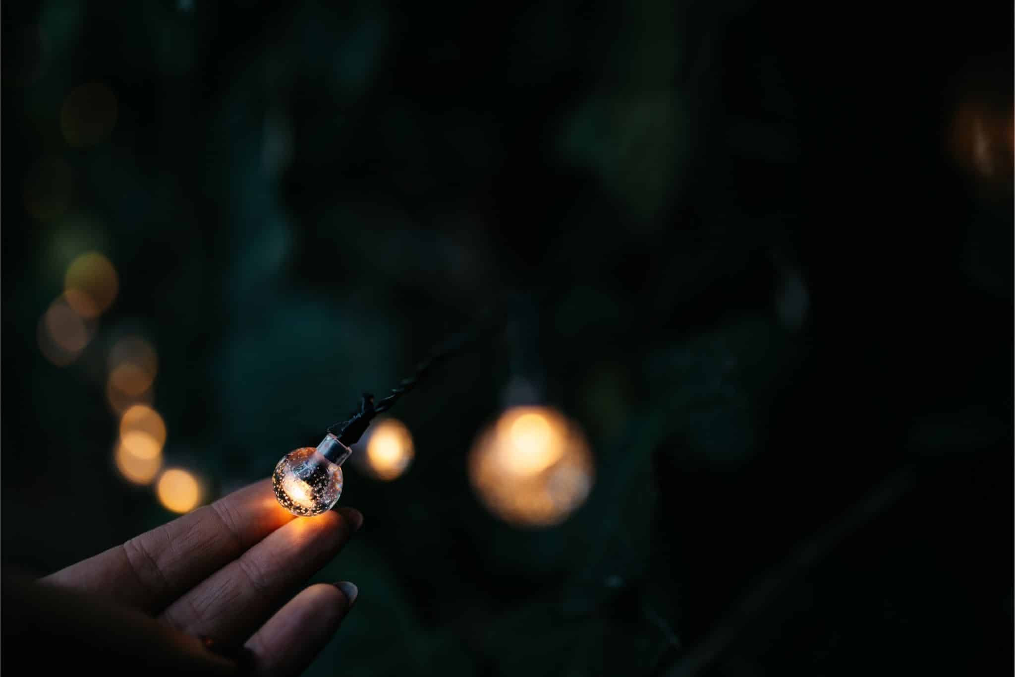 Romantic solar fairy lights, bubble lights, and flickering tea lights glowing under a tree.