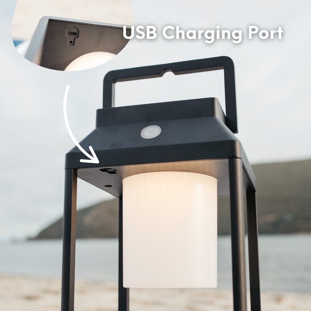 Black solar LED lantern mounted on outdoor wall with soft glow