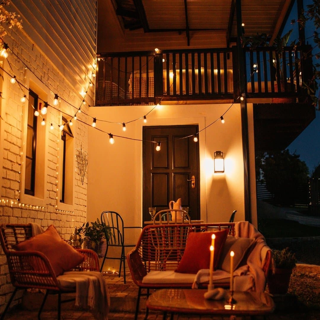 Black solar LED lantern mounted on outdoor wall with soft glow