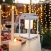 Portable white solar LED lantern on table and wall, warm light glow