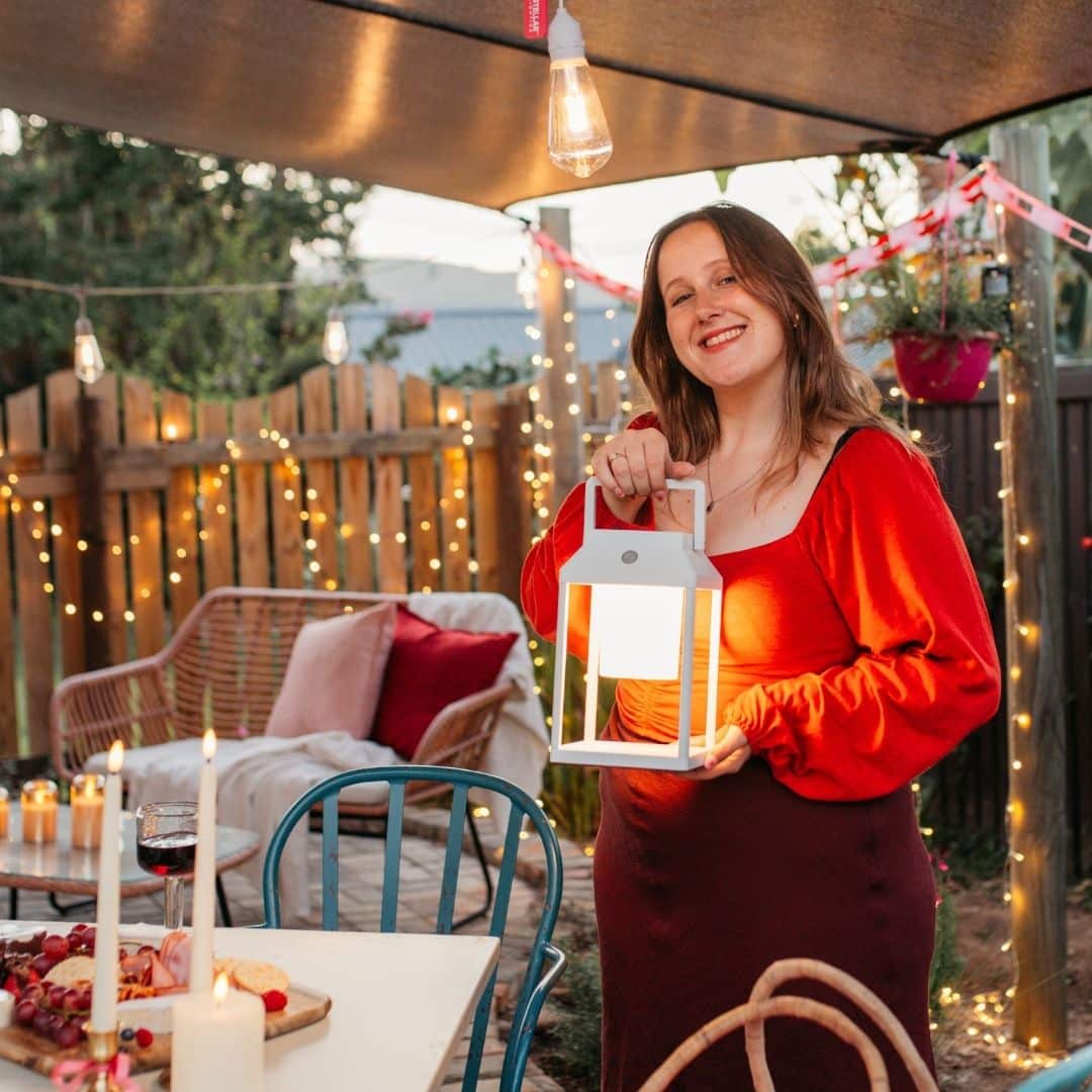 Portable white solar LED lantern on table and wall, warm light glow