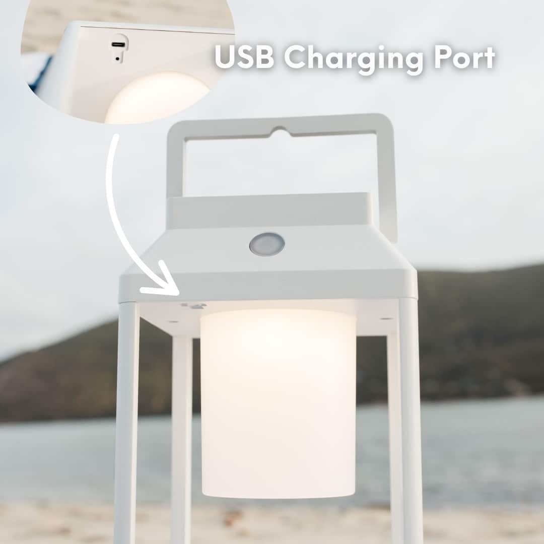 Portable white solar LED lantern on table and wall, warm light glow