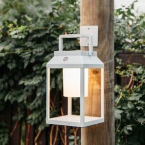 Portable white solar LED lantern on table and wall, warm light glow