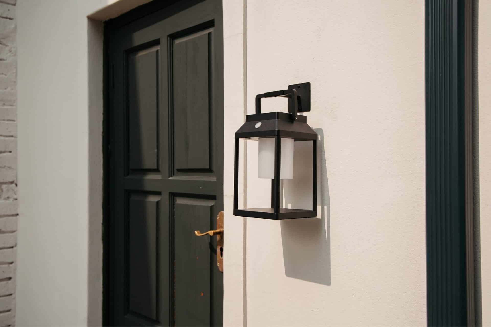 Black Solar Glow Lantern – Weatherproof Outdoor Light Black solar LED lantern mounted on outdoor wall with soft glow