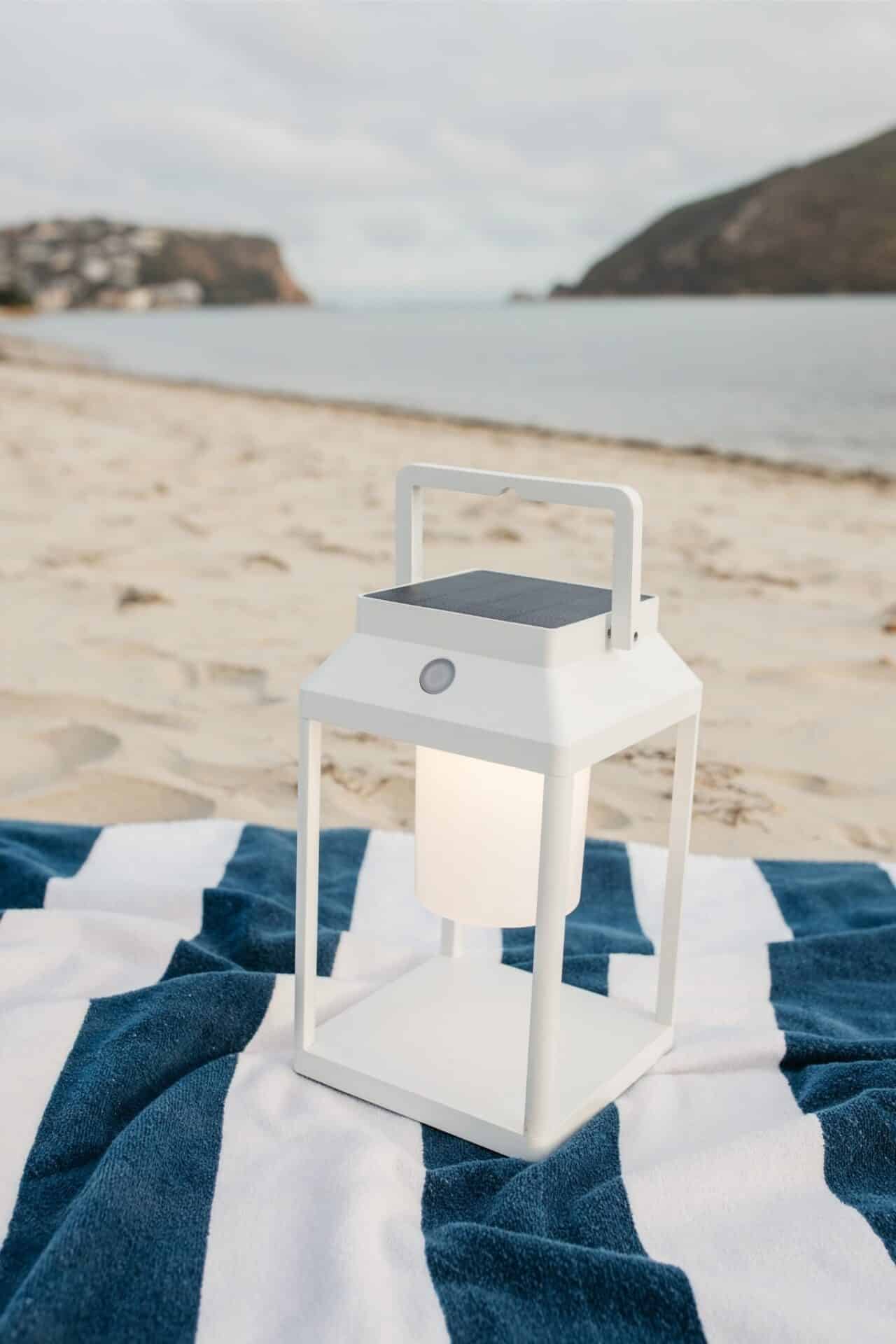 Portable white solar LED lantern on table and wall, warm light glow