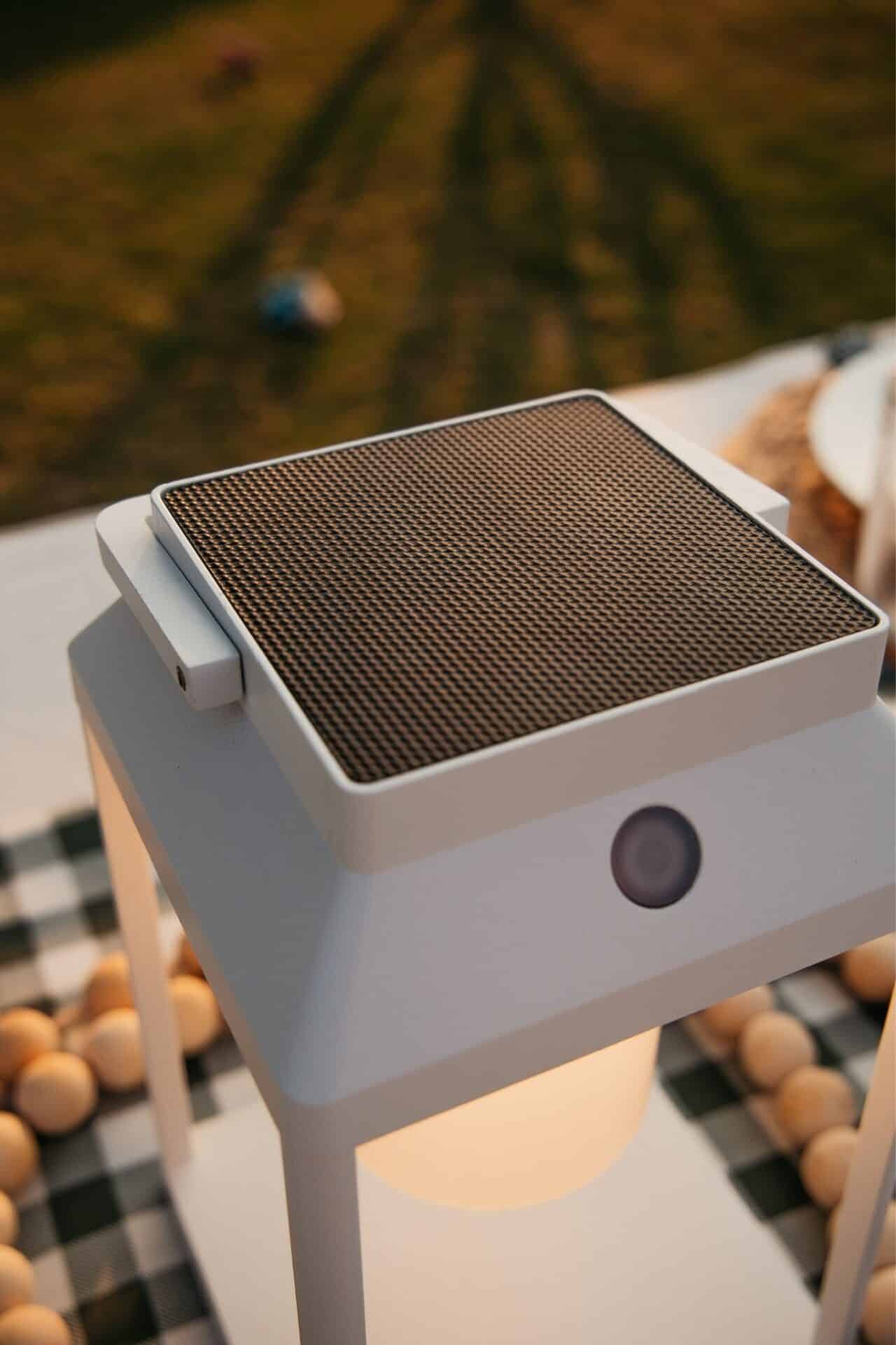 Portable white solar LED lantern on table and wall, warm light glow