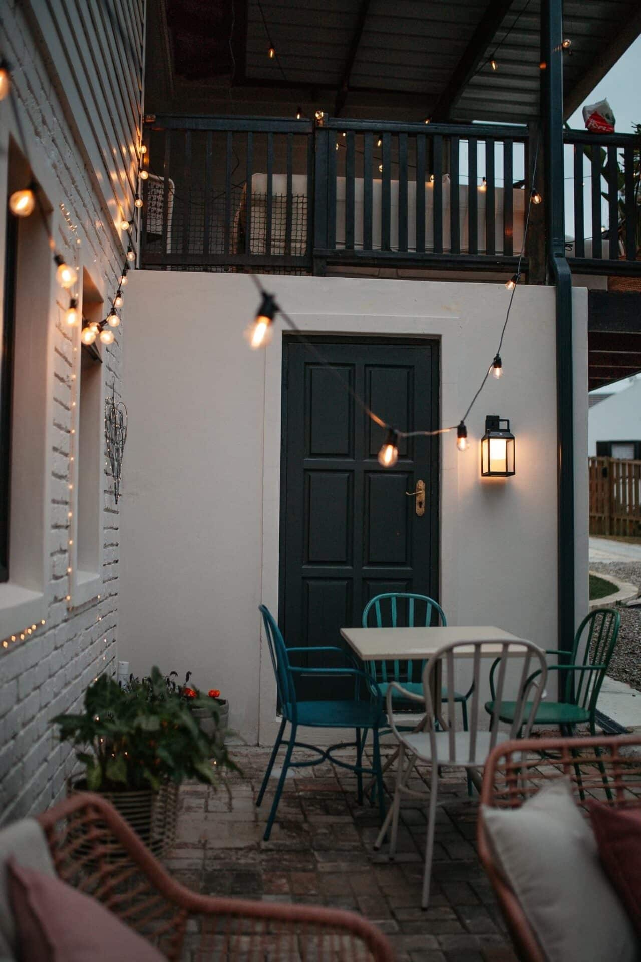 Black solar LED lantern mounted on outdoor wall with soft glow