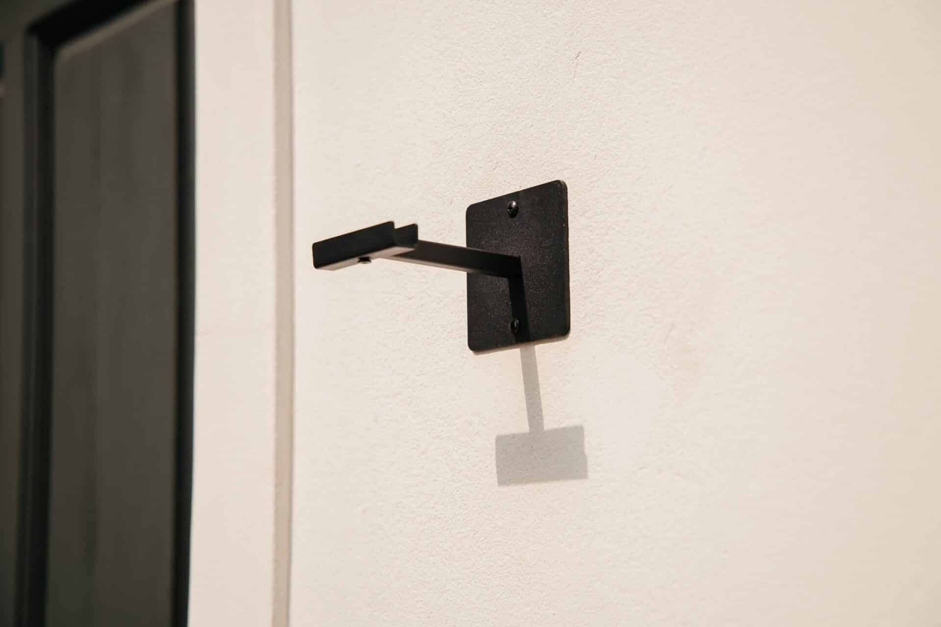 Black solar LED lantern mounted on outdoor wall with soft glow