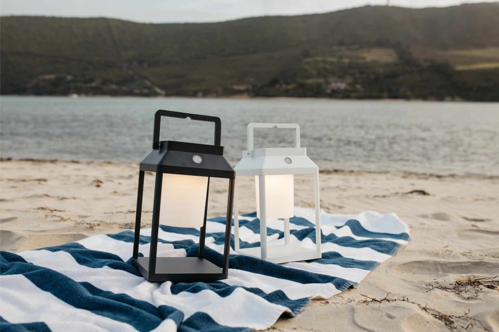 Black solar LED lantern mounted on outdoor wall with soft glow