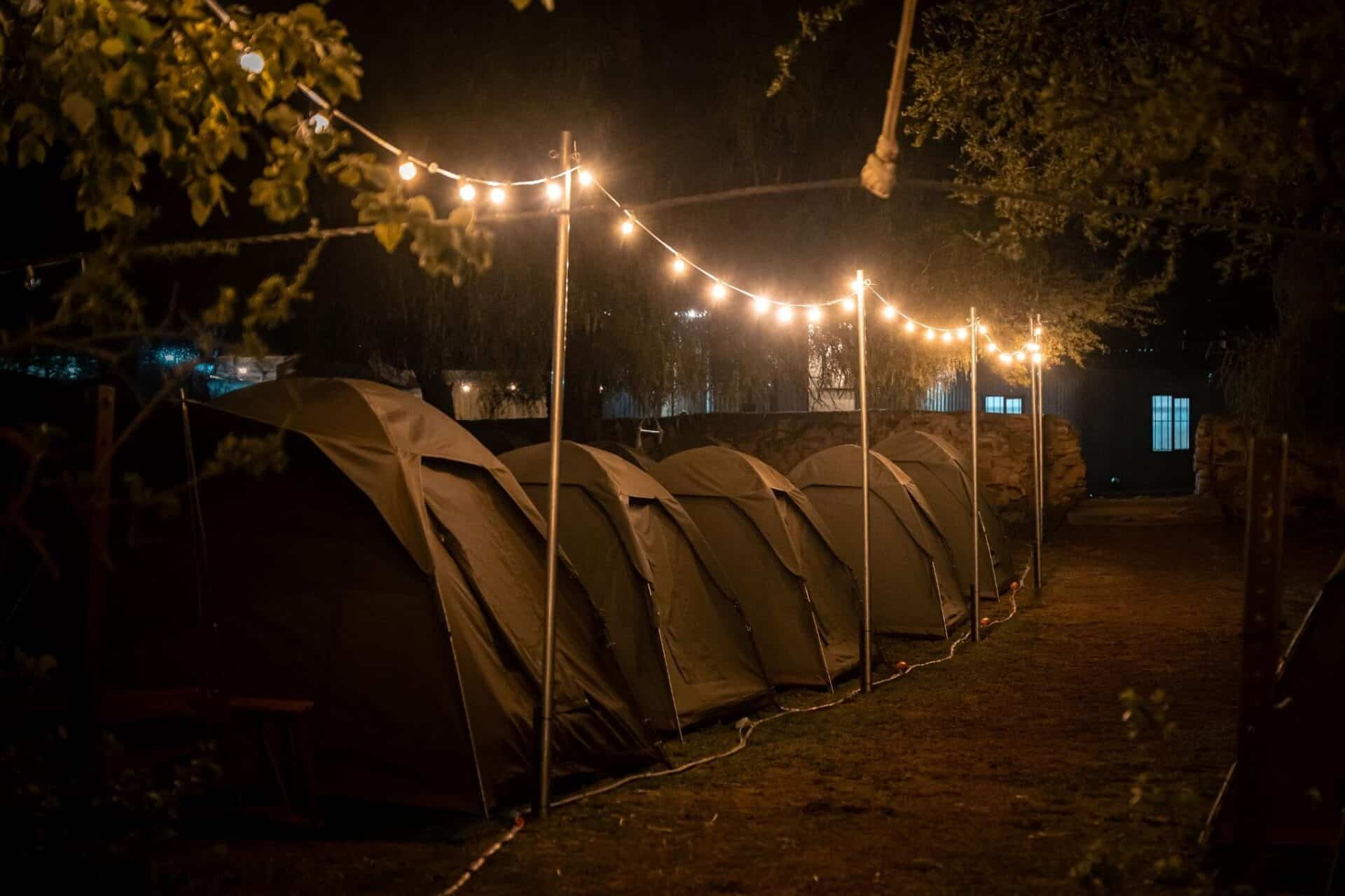 Festoon string lights glowing at Ride the Karoo campsite at sunset