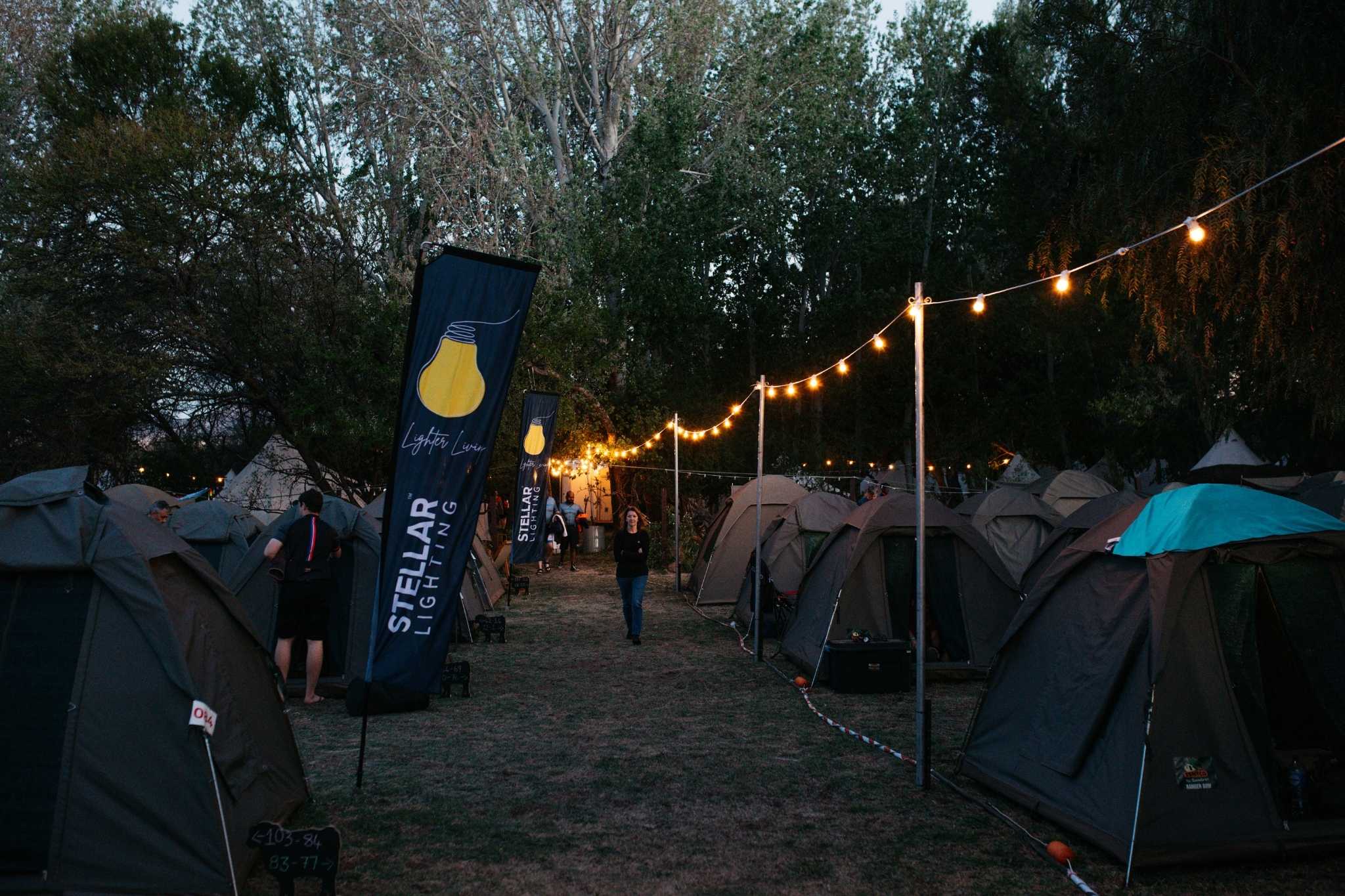 Festoon string lights glowing at Ride the Karoo campsite at sunset