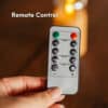 Remote control for LED flameless candle set showing dimmer and timer options