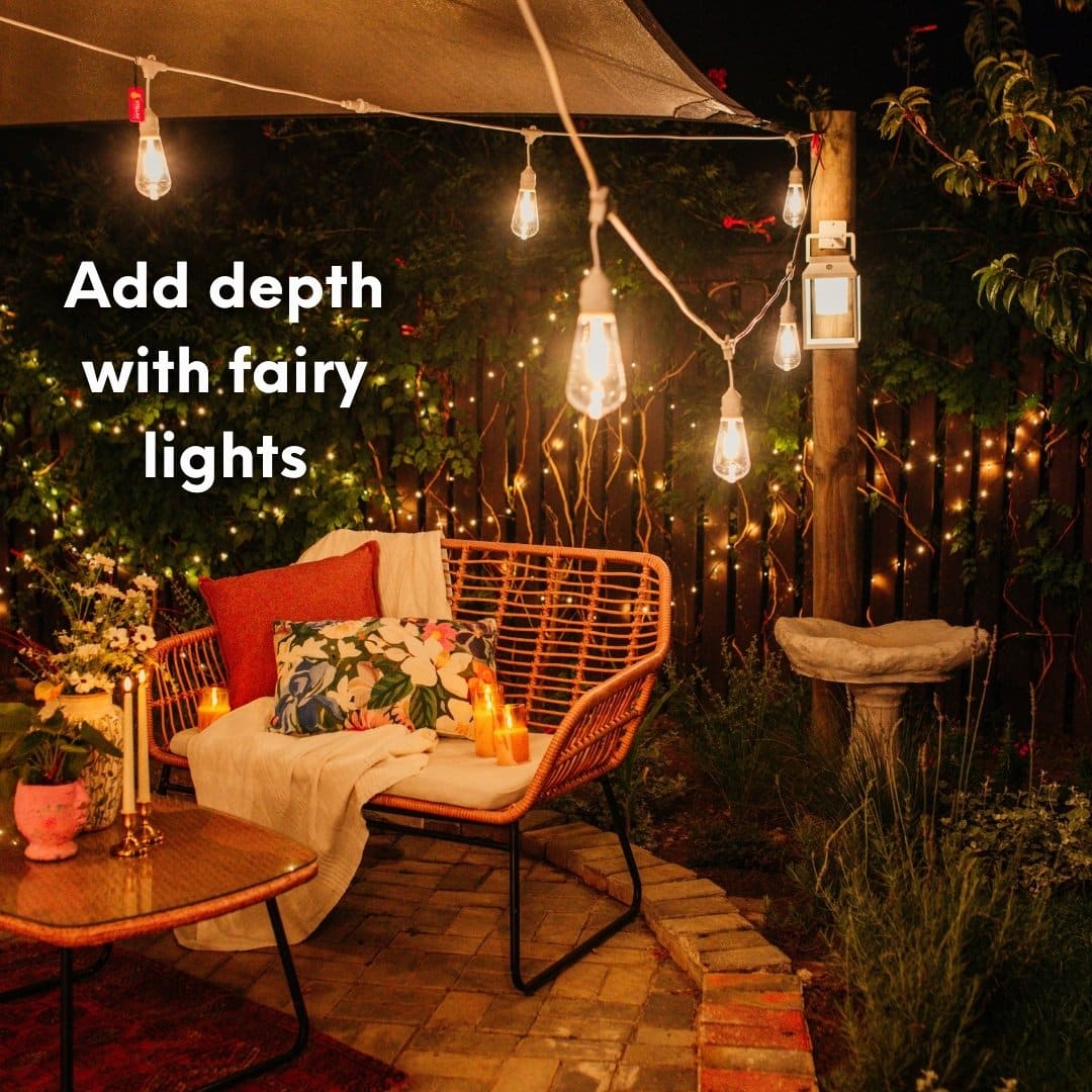 30m heavy duty warm white fairy lights showing the thick dark green cable and dense LED spacing against a fence.