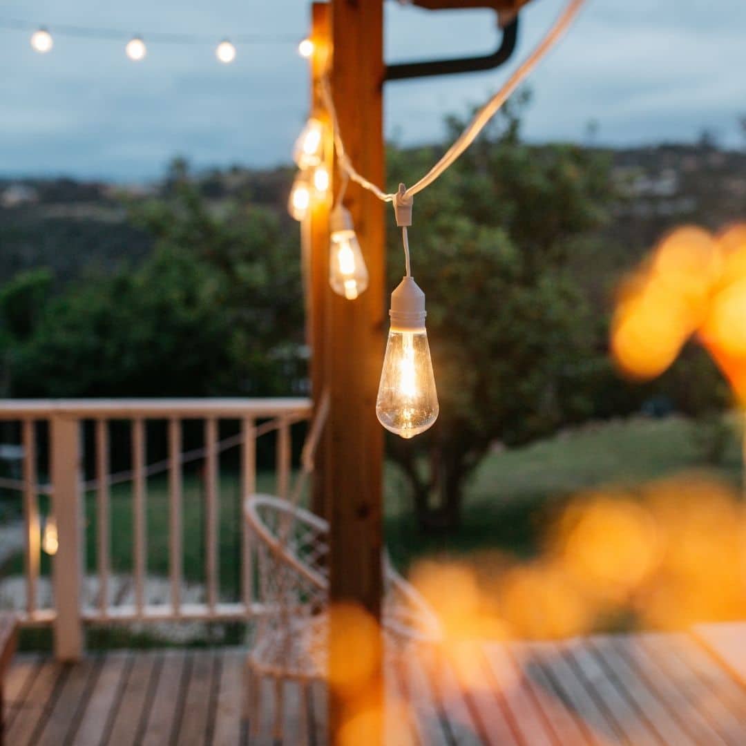 10m white festoon string lights with warm ST64 LED bulbs glowing outdoors