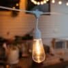 10m white festoon string lights with warm ST64 LED bulbs glowing outdoors