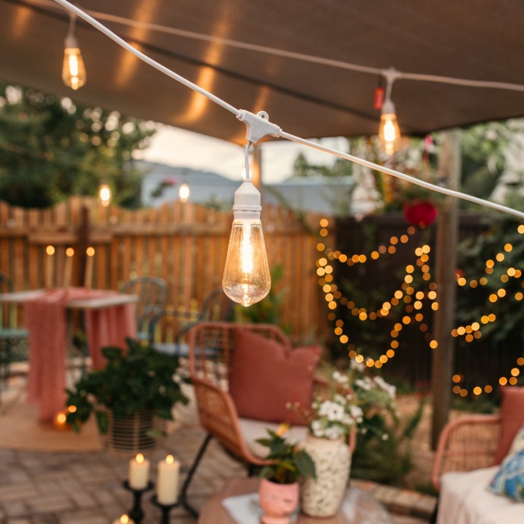 10m white festoon string lights with warm ST64 LED bulbs glowing outdoors