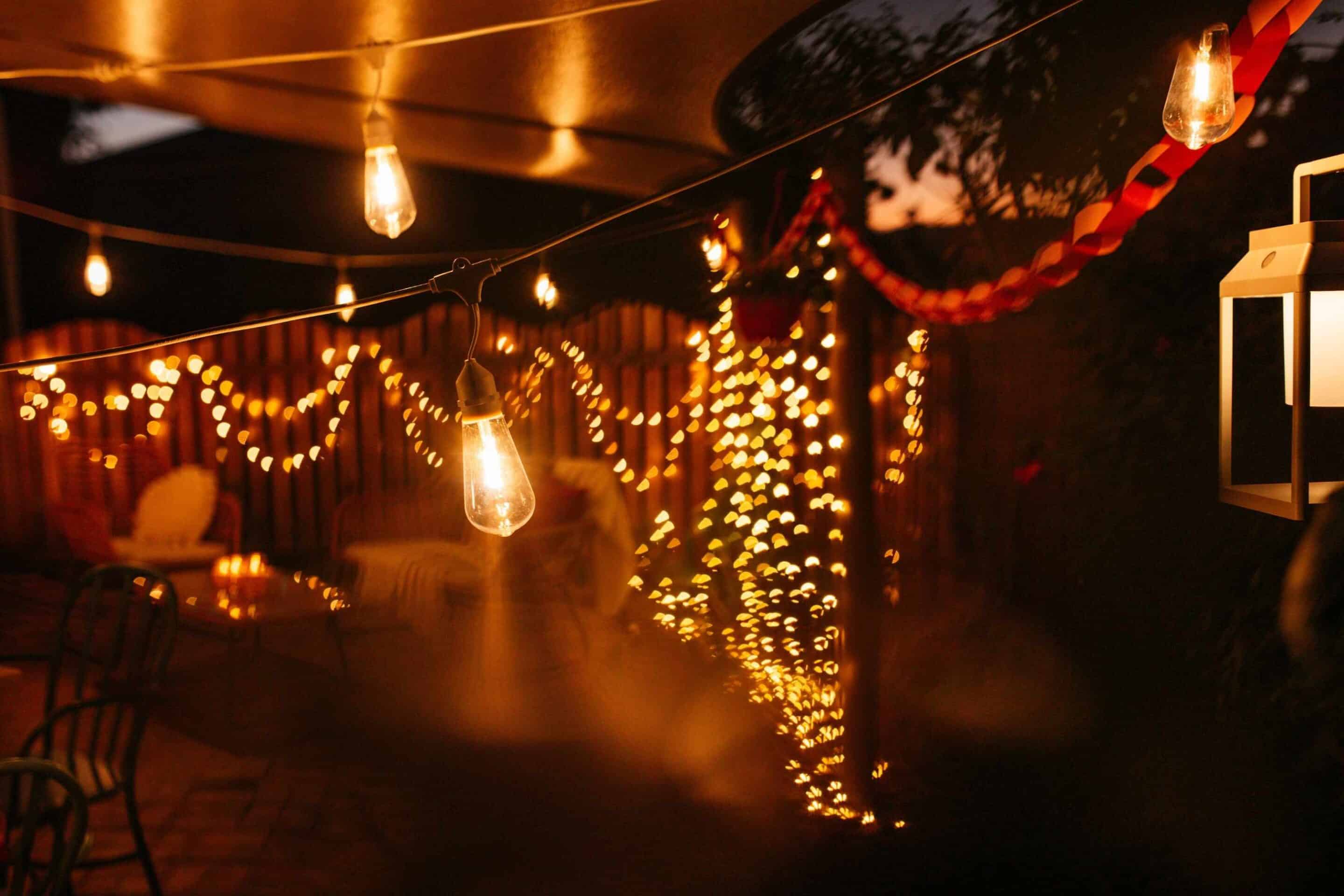 Romantic outdoor Valentine’s Day lighting with festoon lights, lanterns, and candles