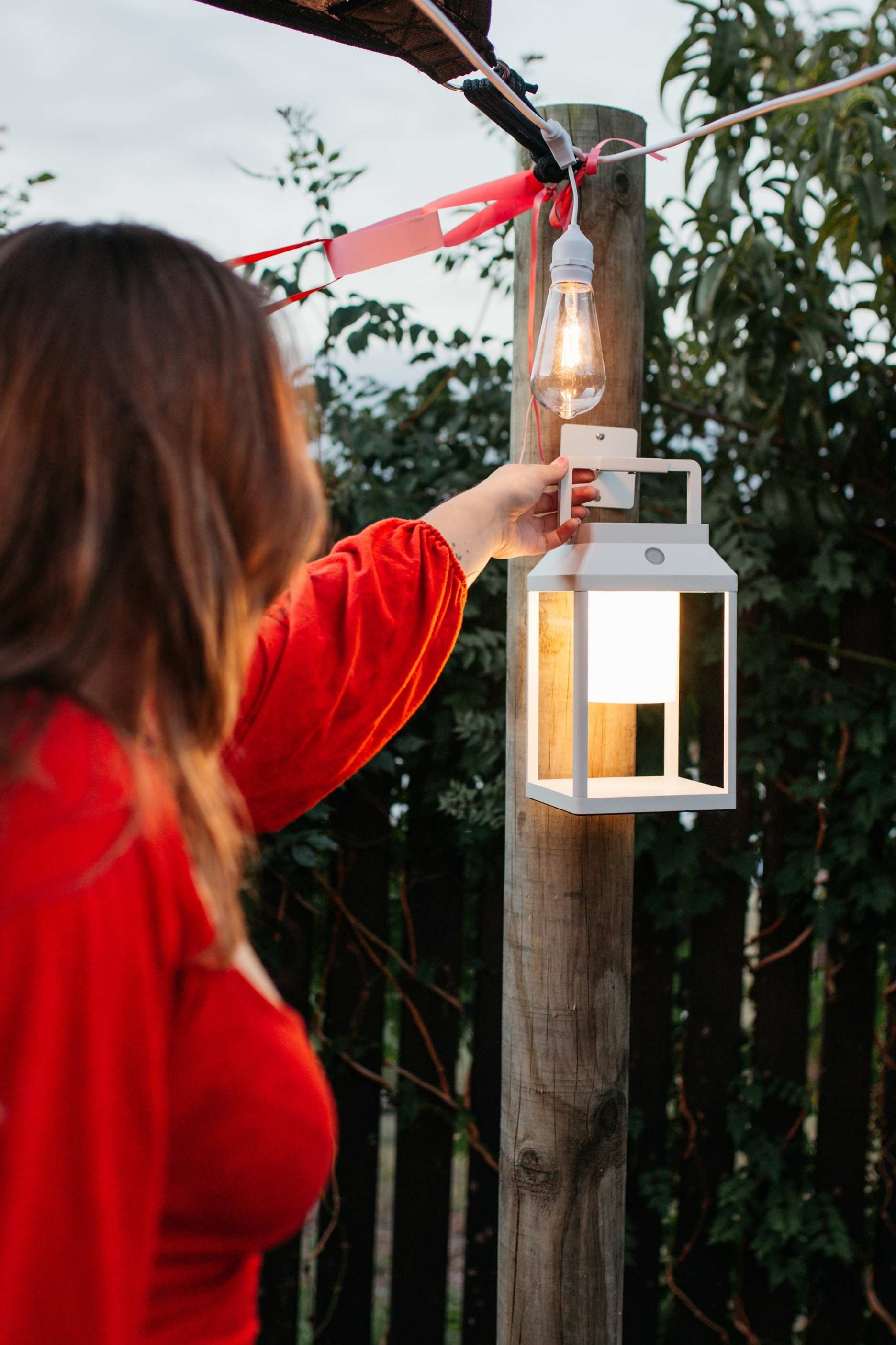 Romantic outdoor Valentine’s Day lighting with festoon lights, lanterns, and candles